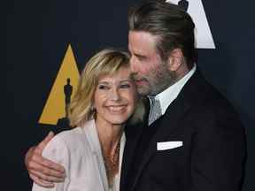 Dans cette photo d'archive prise le 15 août 2018, les acteurs Olivia Newton-John et John Travolta posent sur le tapis rouge à leur arrivée pour la célébration du 40e anniversaire du film 