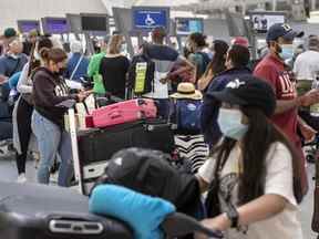 Les voyageurs font la queue au terminal 1 de l'aéroport international Pearson de Toronto alors que les retards se poursuivent, le jeudi 7 juillet 2022.