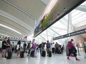 Les gens font la queue avant d'entrer dans la sécurité à l'aéroport international Pearson de Toronto le vendredi 5 août 2022.