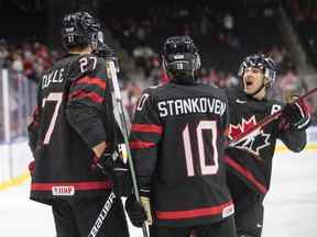 Les Canadiens Will Cuylle (27), Logan Stankoven (10) et Donovan Sebrango (7) célèbrent un but contre la Suisse lors de la deuxième période du quart de finale du Championnat mondial de hockey junior de l'IIHF à Edmonton, le mercredi 17 août 2022.