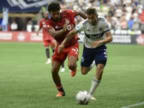 26 juillet 2022 ;  Vancouver, Colombie-Britannique, Canada ;  Le défenseur du Vancouver Whitecaps FC Marcus Godinho déplace le ballon contre le milieu de terrain du Toronto FC Kosi Thompson au cours de la seconde moitié à BC Place.