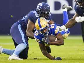 Greg McCrae des Blue Bombers de Winnipeg est plaqué par Ja'Gared Davis des Argonauts de Toronto.