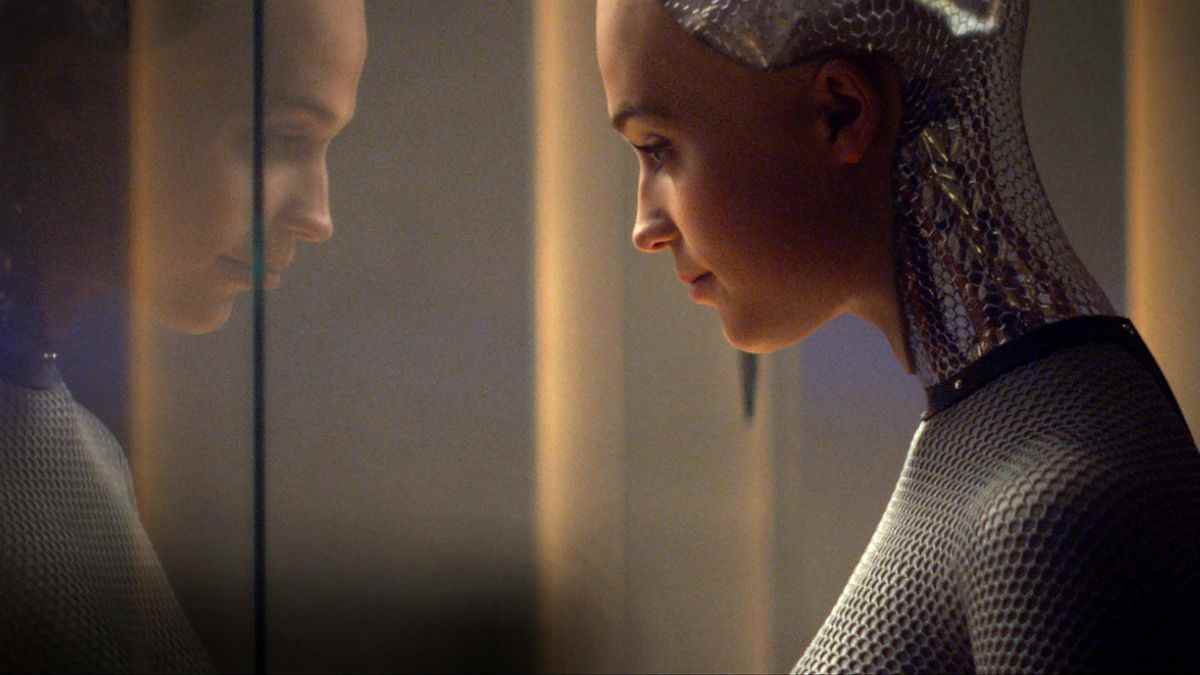 Alicia Vikander dans le rôle d'Ava regardant à travers une vitre son propre reflet dans Ex Machina.