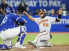 Ramon Urias des Orioles de Baltimore glisse à la maison en toute sécurité pour marquer sur un simple de Ryan McKenna contre les Blue Jays en sixième manche mardi soir au Rogers Centre.