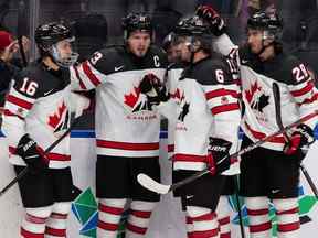 Mason McTavish (23 ans) d'Équipe Canada célèbre un but du tour du chapeau avec ses coéquipiers lors de la deuxième période du Championnat mondial de hockey junior à Rogers Place à Edmonton le jeudi 11 août 2022.