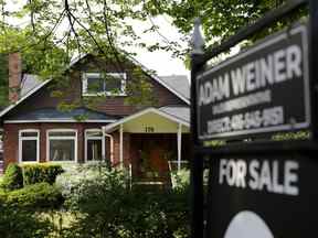 L'enseigne d'un agent immobilier à l'extérieur d'une maison à vendre à Toronto.