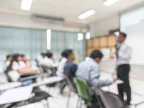 Arrière-plan abstrait flou d'étudiants assis en classe avec un enseignant devant la classe.