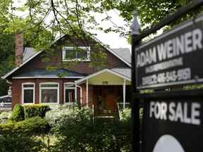 L'enseigne d'un agent immobilier à l'extérieur d'une maison à vendre à Toronto.