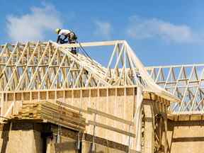 Un travailleur de la construction travaille sur une nouvelle maison en construction dans une banlieue située au nord de Toronto à Vaughan.