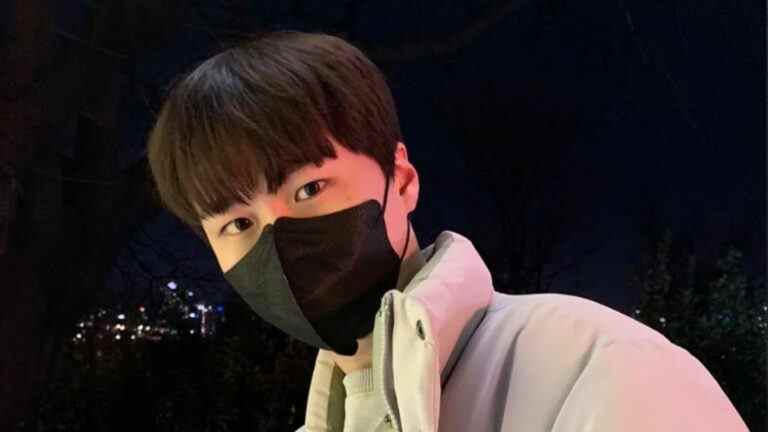 Overwatch pro Myunbong dons a black face mask and an off-white puffer jacket, pictured from the shoulders up.