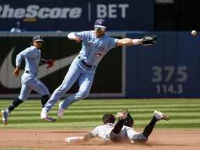 Whit Merrifield des Blue Jays rate la prise alors que Tyler Freeman des Cleveland Guardians vole la deuxième base en quatrième manche au Rogers Center le dimanche 14 août 2022.