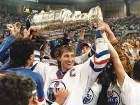 Le capitaine de l'équipe des Oilers d'Edmonton Wayne Gretzky brandit le trophée de la coupe Stanley après avoir remporté la finale de la coupe Stanley à Edmonton le 1er juin 1987.