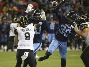 Hamilton Tiger Cats, Jeremiah Masoli QB (8) a ses blocages de passes par les Argonauts de Toronto Travis Feeney DL (30) lors de l'action de la LCF à Toronto, Ont.  le vendredi 12 novembre 2021.