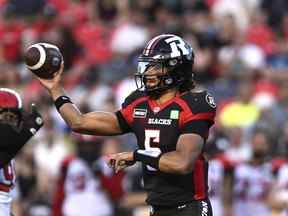 Le quart-arrière des Redblacks d'Ottawa Caleb Evans (5) lance le ballon lors de l'action de football de la première mi-temps de la LCF contre les Stampeders de Calgary à Ottawa le vendredi 5 août 2022.