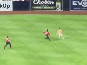 Un streaker portant des sous-vêtements est poursuivi par la sécurité lors d'un match des Padres contre les Twins à San Diego le samedi 30 juillet 2022.