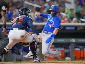 4 août 2022 ;  Minneapolis, Minnesota, États-Unis ;  Le voltigeur de centre des Blue Jays de Toronto Whit Merrifield (1) glisse à la maison contre le receveur des Twins du Minnesota Gary Sanchez (24) en huitième manche au Target Field.