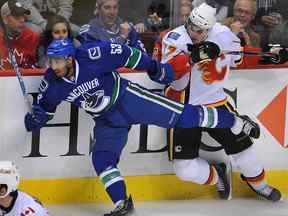 Prab Rai frappe fort Lance Bouma des Flames de Calgary lors d'un match de pré-saison au Rogers Arena en 2010.