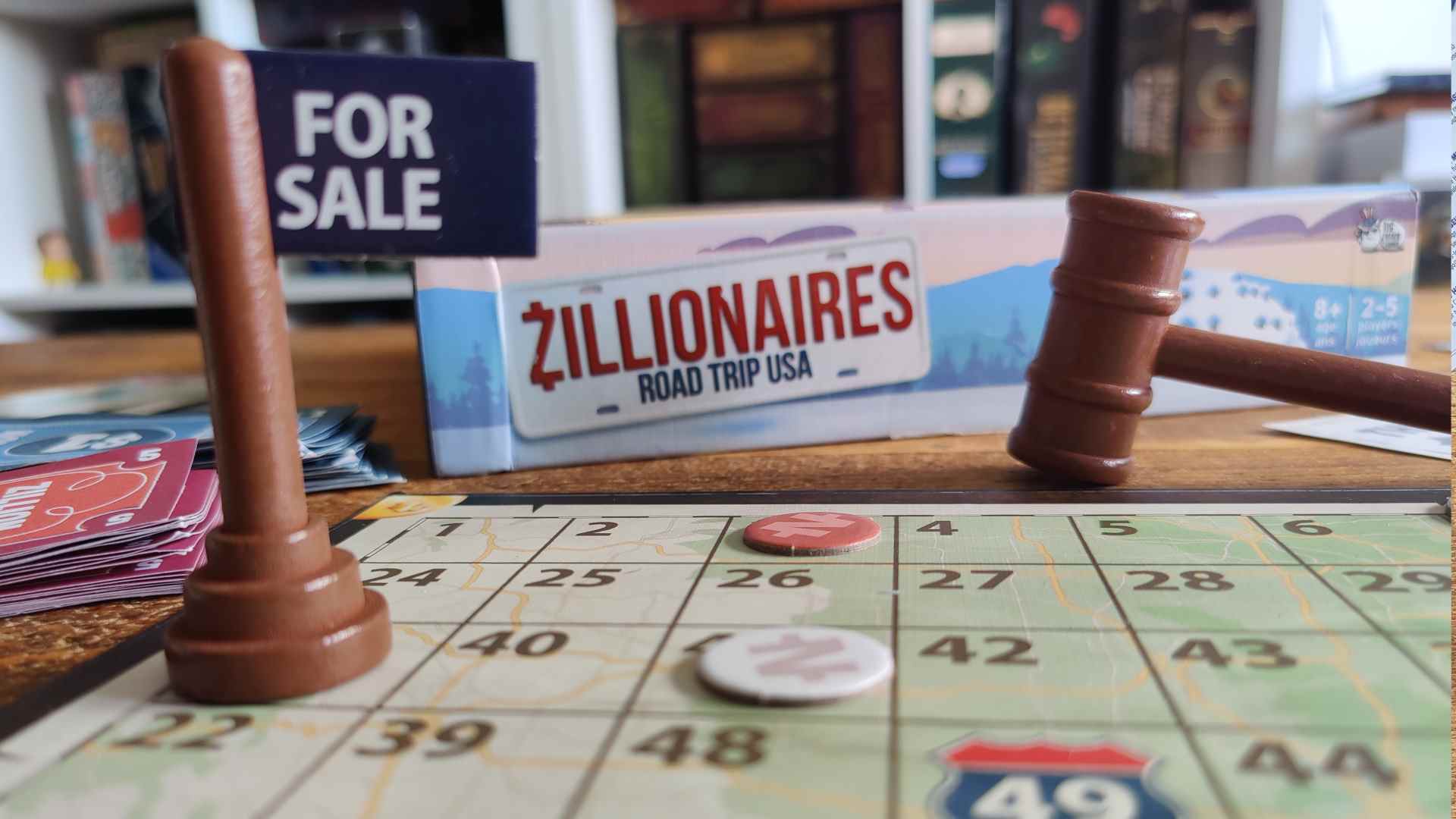 Zillionaires : Road Trip USA gros plan de la boîte, du tableau, de l'enseigne à vendre et du marteau