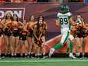 Le demi en retrait des Roughriders de la Saskatchewan Kian Schaffer-Baker (89) dépasse les cheerleaders des Lions de la Colombie-Britannique avant de marquer un touché en première demie au BC Place.  le vendredi. 