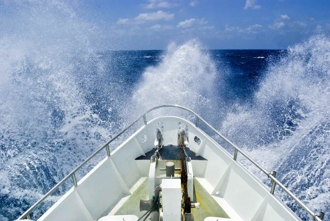 La proue d'un navire traverse une mer agitée et embruns en pleine mer.