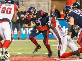 Le quart-arrière des Alouettes Trevor Harris n'arrive pas à franchir la ligne défensive du Rouge et Noir et est plaqué par Lorenzo Mauldin IV lors de la première moitié du match de vendredi.