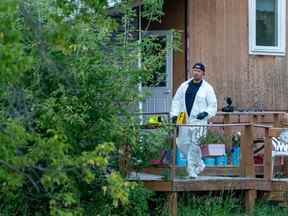 Un policier en équipement de protection marche sur une scène de crime à Weldon, en Saskatchewan, le dimanche 4 septembre 2022.