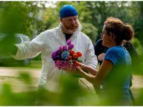 Ruby Works s'entretient avec un enquêteur médico-légal avant d'apporter des fleurs au domicile d'une victime qui a été identifiée par des résidents comme étant Wes Petterson à Weldon, en Saskatchewan, le lundi 5 septembre 2022. Works a déclaré que la victime de 77 ans était comme un oncle pour elle.