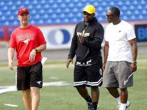 L'entraîneur-chef des Stampeders de Calgary Dave Dickenson avec les anciens joueurs LR, Keon Raymond et Brandon Smith lors de l'entraînement au stade McMahon en préparation du match de la fête du Travail à Calgary le samedi 3 septembre 2022.