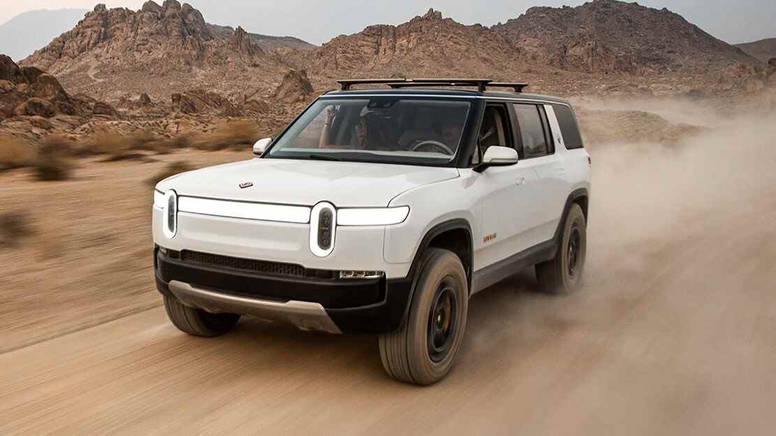 rivian blanc r1s conduisant à travers le désert