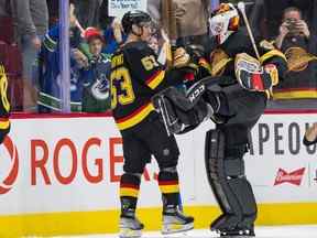 Le capitaine des Canucks Bo Horvat félicite le gardien Thatcher Demko alors que le duo célèbre la victoire 7-1 des Canucks contre les Flames de Calgary au Rogers Arena le 24 février 2022.