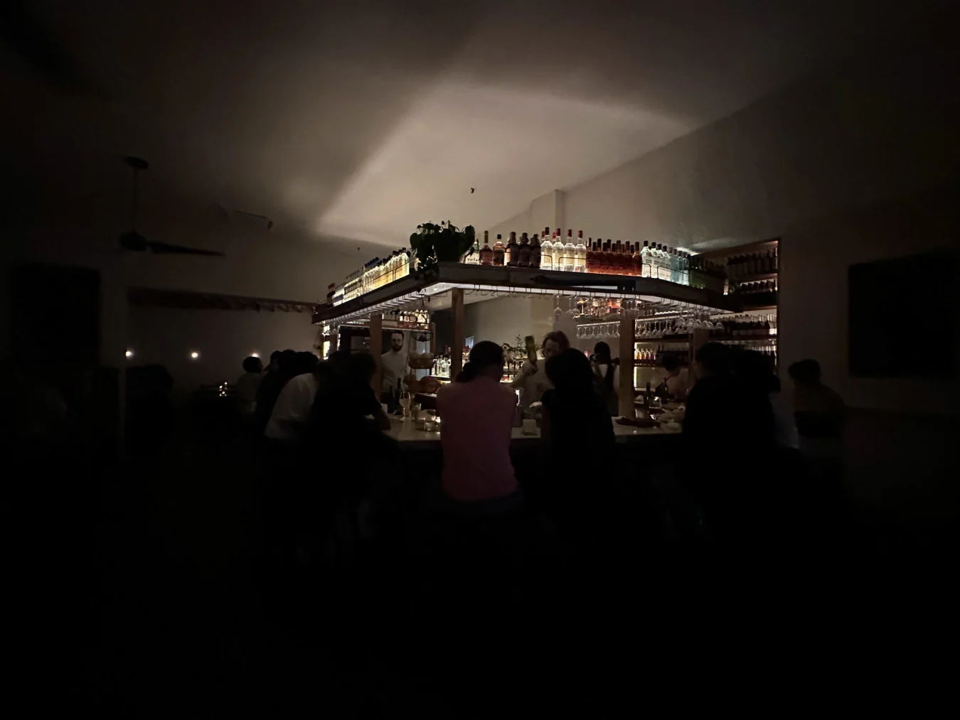 Une photo de l'appareil photo large de l'iPhone 14 Pro d'un bar lumineux dans un restaurant sombre.