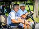 L'entraîneur-chef des Canadiens de Montréal, Martin St. Louis, à gauche, partage une voiturette avec le directeur général Kent Hughes lors du tournoi de golf annuel de l'équipe à Laval, le 11 septembre 2022.