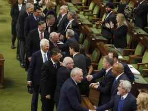 Le premier ministre Justin Trudeau s'entretient avec Paul Henderson et des membres d'Équipe Canada de la série des sommets de 1972 alors qu'ils sont honorés à la Chambre des communes, à Ottawa, le jeudi 22 septembre 2022. LA PRESSE CANADIENNE/Patrick Doyle