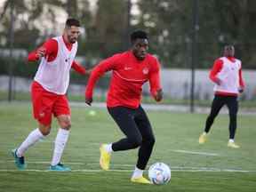 L'attaquant canadien Alphonso Davies contrôle le ballon tandis que le défenseur Steven Vitoria le poursuit à la MOL Football Academy de Dunajská Streda, en Slovaquie, le 20 septembre 2022.