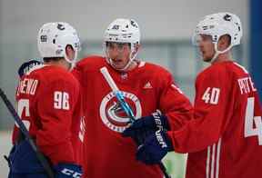 Ilya Mikheyev, des Canucks de Vancouver, au centre, de Russie, s'entretient avec Andrei Kuzmenko, à gauche, de Russie, et Elias Pettersson, de Suède, lors d'un camp d'entraînement à Whistler.