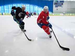 Brock Boeser des Canucks de Vancouver, à droite, tente de garder la rondelle loin du camp d'entraînement d'Oliver Ekman-Larsson à Whistler le jeudi 22 septembre 2022.