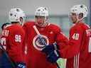 Le New Vancouver Canuck Ilya Mikheyev (au centre) s'entretient avec son nouveau coéquipier russe Andrey Kuzmenko tandis qu'Elias Pettersson (à droite) attend de passer un mot lors de la première journée du camp d'entraînement des Canucks de Vancouver à Whistler le 22 septembre 2022.