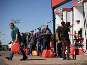 Les résidents locaux font la queue pour remplir des bidons d'essence un jour après que la tempête post-tropicale Fiona a frappé la côte atlantique le 25 septembre 2022 à New London, Île-du-Prince-Édouard, Canada.  On estime que 80 000 résidents de l'Île-du-Prince-Édouard sont restés sans électricité.  Anciennement l'ouragan Fiona, la tempête déclassée est l'une des plus fortes que la côte atlantique du Canada ait connues depuis des années.