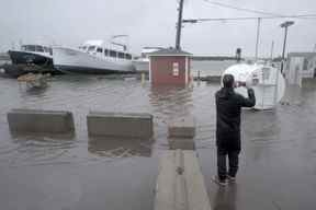 Un résident prend des photos d'inondations après le passage de l'ouragan Fiona, plus tard déclassé en cyclone post-tropical, à Shediac, NB, le 24 septembre 2022.