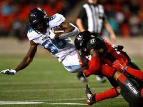 Le receveur large des Argonauts Damonte Coxie est plaqué par le secondeur des Redblacks Frankie Griffin au cours de la première mi-temps.