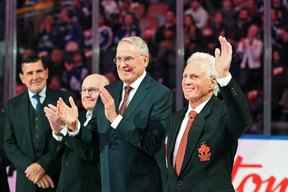 Paul Henderson, ancien joueur de la LNH et d'Équipe Canada, salue les applaudissements de ses coéquipiers (de droite à gauche) Ken Dryden, Ron Ellis et Serge Savard lors d'une cérémonie en l'honneur des membres de l'équipe qui a joué dans la série des sommets de 1972 contre l'Union soviétique.  La cérémonie a précédé le match préparatoire entre les Canadiens de Montréal et les Maple Leafs de Toronto au Scotiabank Arena de Toronto le mercredi 28 septembre 2022.