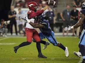 20 août 2022 ;  Toronto, Ontario, CAN ;  Le quart-arrière des Stampeders de Calgary Jake Maier (12 ans) lance une passe alors qu'il est frappé par le joueur de ligne défensive des Argonauts de Toronto Robbie Smith (40 ans) au cours de la seconde moitié au BMO Field.