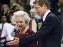 Wayne Gretzky escorte la reine Elizabeth II au centre de la glace pour un face-à-face de cérémonie à GM Place à Vancouver le dimanche 6 octobre 2002.