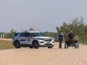 Un agent de la GRC s'entretient avec un résident de la nation crie de James Smith après avoir signalé une possible observation de Myles Sanderson dans la réserve.  Photo prise à la Nation crie de James Smith, SK, le mardi 6 septembre 2022.