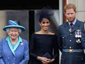 La reine, Meghan, duchesse de Sussex et le prince Harry, duc de Sussex, regardent le défilé aérien de la RAF sur le balcon du palais de Buckingham, alors que des membres de la famille royale assistent à des événements marquant le centenaire de la RAF le 10 juillet 2018 à Londres.