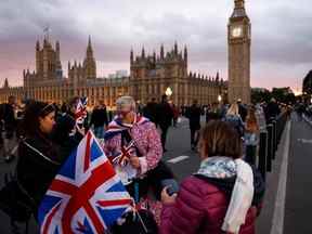 Un vendeur de rue vend des drapeaux Union Jack à des sympathisants sur le pont de Westminster à Londres le 18 septembre 2022, après la mort de la reine Elizabeth II le 8 septembre.