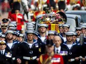 Des marins de la Royal Navy marchent devant et derrière le cercueil de la reine Elizabeth II, drapé dans le Royal Standard, alors qu'il se rend de l'abbaye de Westminster à l'arche de Wellington à Londres le 19 septembre 2022.