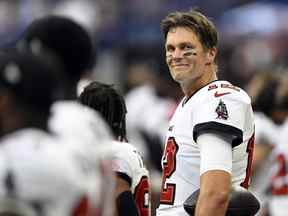 Le quart-arrière des Buccaneers de Tampa Bay, Tom Brady (12 ans), sourit pendant l'hymne national avant le match contre les Colts d'Indianapolis.