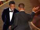 Will Smith (R) se balance pour frapper Chris Rock sur scène lors de la 94e cérémonie des Oscars à Hollywood, Los Angeles, Californie, États-Unis, le 27 mars 2022.