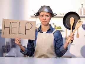 Femme au foyer inexpérimentée demandant de l'aide pour cuisiner, portant un pot sur la tête, blague